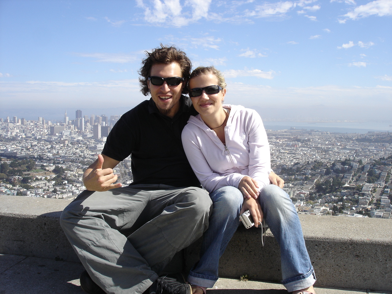 Two people smile and hug in front of Twin Peaks